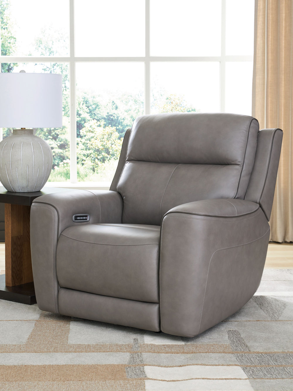 Masterfully blend high style and must-have comfort with this power recliner. Its clean, transitional look is crafted with luxury in mind, complete with supple top-grain leather in the seating area. Eloquently incorporated into the sleek design are feature