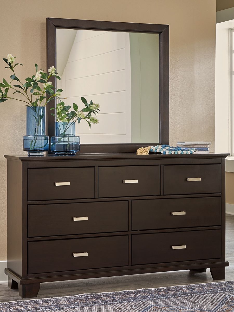 Feast your eyes on this richly versatile dresser with mirror. Its traditional-inspired dark brown finish effortlessly blends with contemporary bright nickel-tone pulls to create a stunning look that-'s not too stuffy or too trendy. Spacious drawers offer 