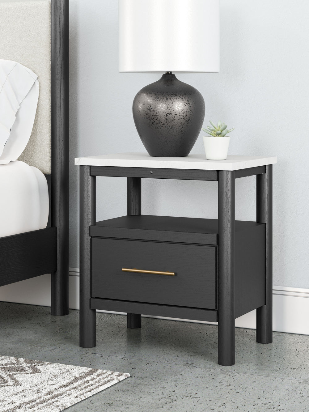 This nightstand reflects your sophisticated approach to boho style. Crafted with both form and function in mind, its replicated marble top beautifully contrasts a matte black finish. The chic and convenient bedside companion offers ambient lighting, along