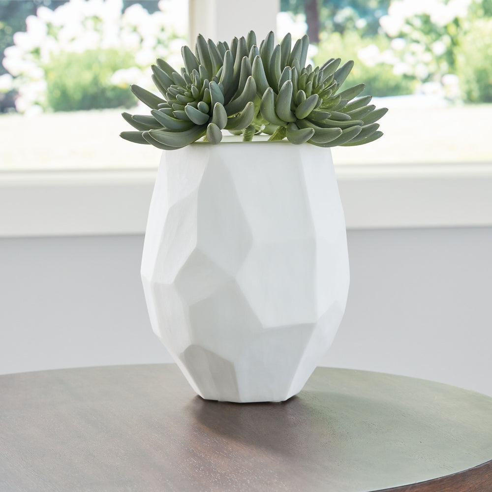 Equal parts elegant and organic, this vase brings ethereal beauty to your tabletop. Its white finish seamlessly harmonizes with existing accents. Meticulous craftsmanship creates the unique, faceted look of the hand-carved surface and makes each piece one