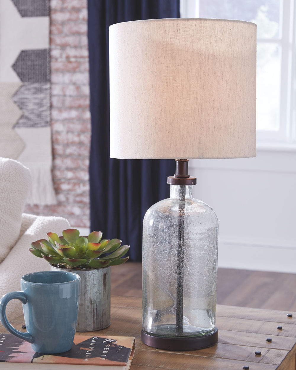 At home in urban industrial or modern farmhouse settings, this seeded glass lamp illuminates a cool vibe in any space. The bronze-tone finish gives this piece a vintage slant while the drum shade provides the clean, modern lines you want.<br><br><b>Additi