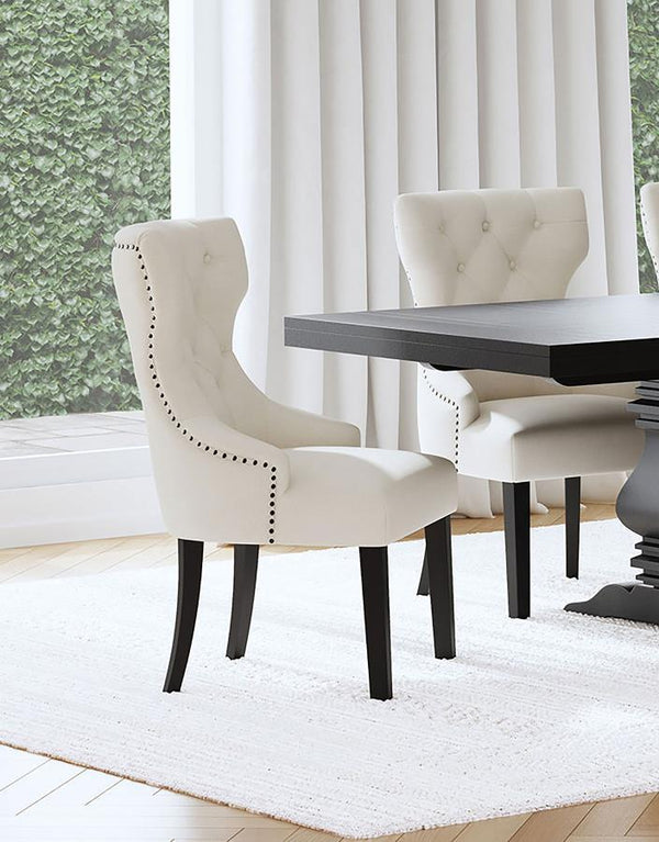  inviting dining room space with a modern button tufted dining chair. It pairs a classic wingback profile with a gentle curvature