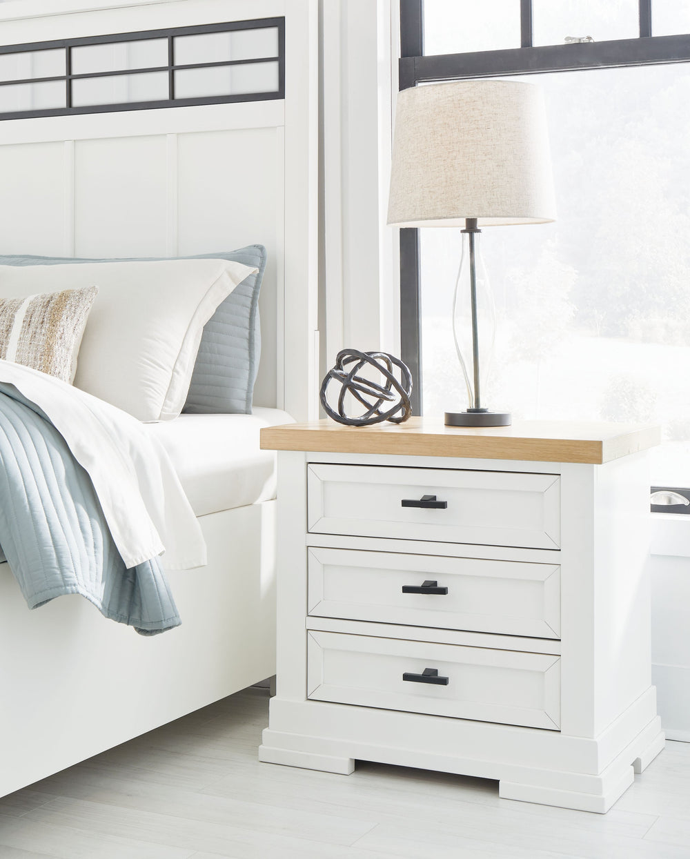 Casual style with substance. This two-tone nightstand raises the bar on comfortably cozy design in your soothing sanctuary. A sturdy silhouette with a classic white finish and black metal hardware exudes modern farmhouse vibes. The butcher block oak venee