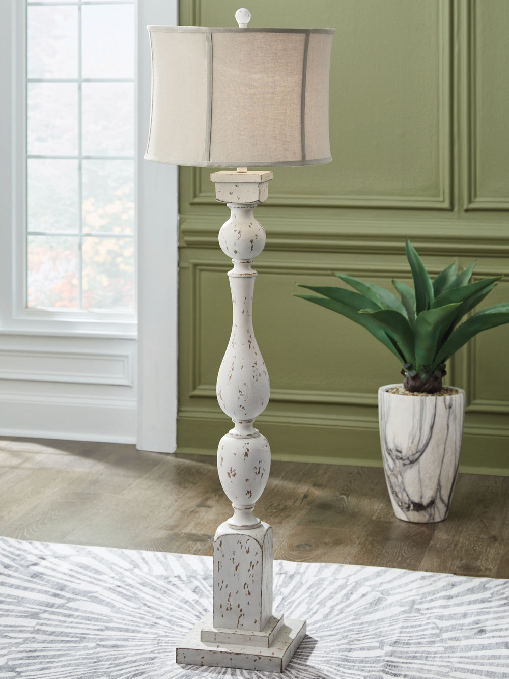 This floor lamp takes a classic approach to tasteful lighting. Its detailed base ushers an air of elegance into your space with a graceful turn design. Outfitted with an antiqued white finish, it-'s right at home in traditional spaces. Pair with the match