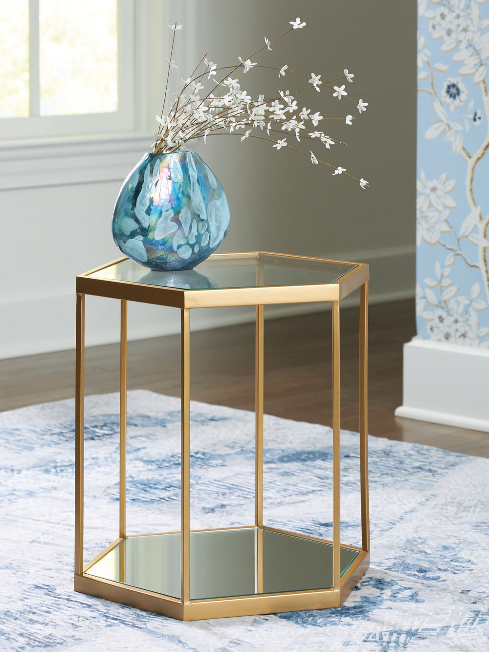With a sleek goldtone frame accenting glass and mirror insets, this striking accent table combines the very best of modern design. Whether you use it to display decor or hold your favorite drink, the hexagonal design makes it a true standout piece in your