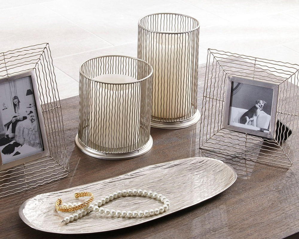 Make some waves with this highly contemporary accessory collection. Wonderfully open and airy, the wavy metal frames and hurricane candle holders beautifully go with the flow. Organic shaped tray is a natural complement.<br><br><b>Additional Dimensions</b