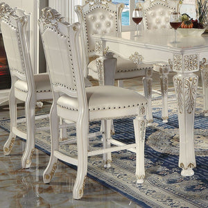 KD, Armless Chair Padded Seat & Back Cushion: PU with Nailhead Trim (Button Tufted Inside Backrest) Wooden Seat Apron with Molding Trim Wooden Tapered Leg & Footrest Supports: Floral Motif