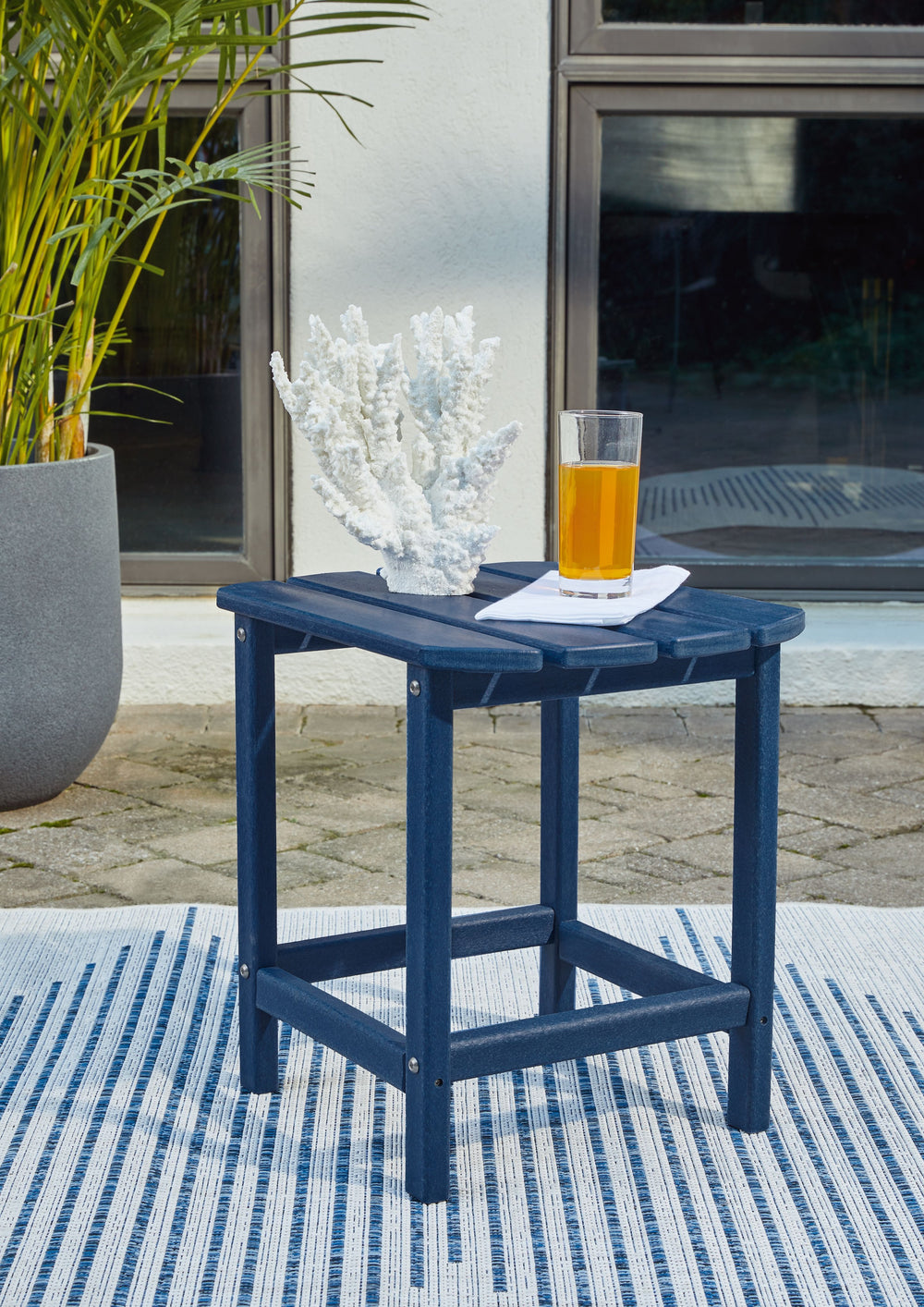 Add cottage-quaint charm to your outdoor oasis with this outdoor end table in blue. Made of MEGA-TUFFÂ® high-density polyethylene material, itâ€™s sure to weather the seasons beautifully. Designed to shed rainwater, the tableâ€™s slatted top with gently r