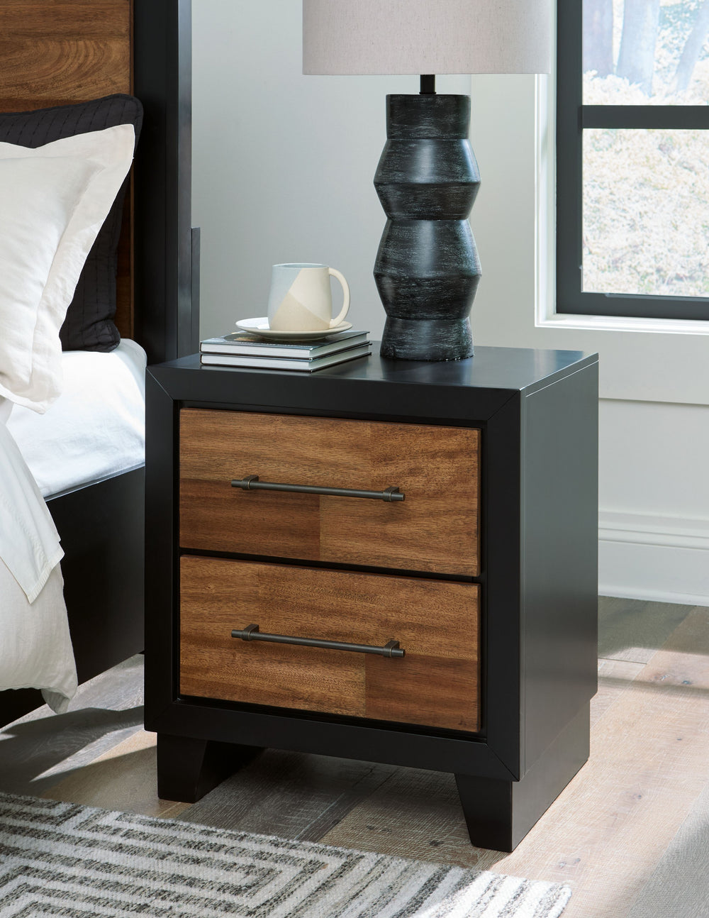 Experience the captivating allure of this nightstand, an effortless blend of casual and refined aesthetics. Its two-tone finish combines satin black with a rich brown wood tone for a modern, relaxed vibe that you-'ll love waking up to. Perfectly suited fo