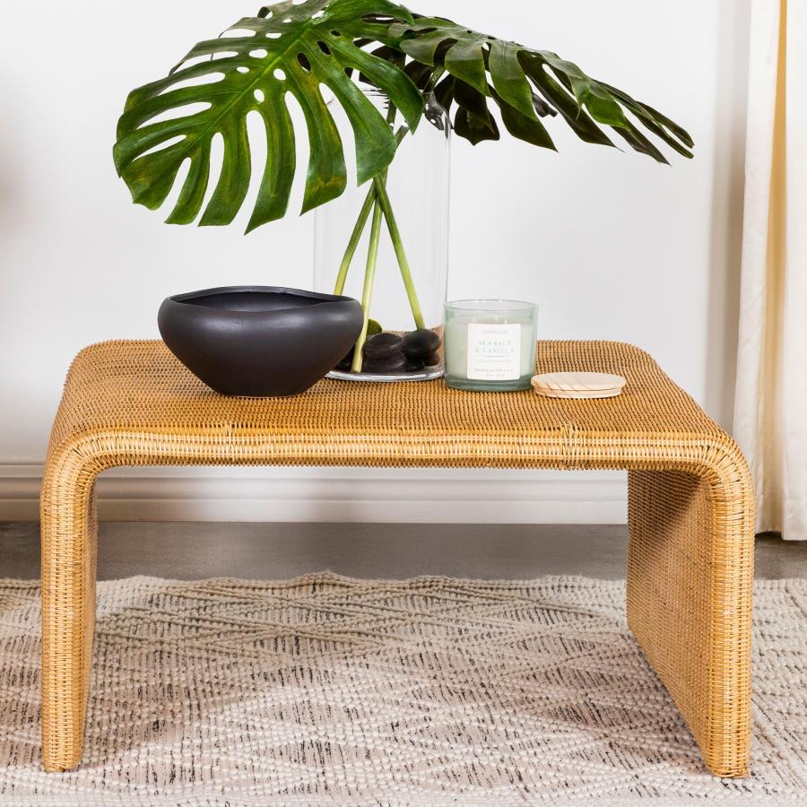 Add a natural, boho touch to your living space with this square coffee table, crafted from woven rattan over a sturdy metal frame. The natural finish enhances its organic texture and mid-century modern appeal. Waterfall edges extend seamlessly to the floo