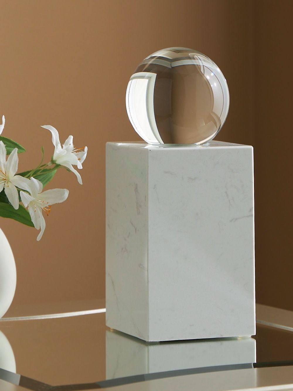 This exquisite sculpture effortlessly combines the purity of clear crystal with the timeless elegance of white marble. Contrasting textures and materials create a captivating visual experience, making it a striking focal point in contemporary settings. It