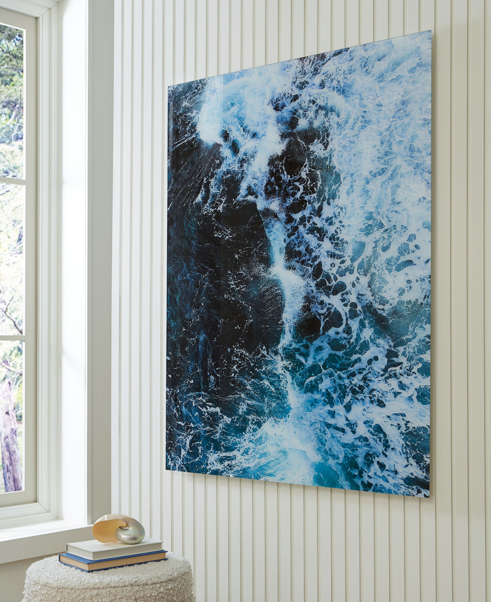 Like waves kissing the shoreline as they crash, this print on glass reminds you of the tide pulling out to sea. Swirling turquoise hues form a mesmerizing image of the ocean with foamy white caps. Perfect for ocean lovers or coastal cottages, this maritim