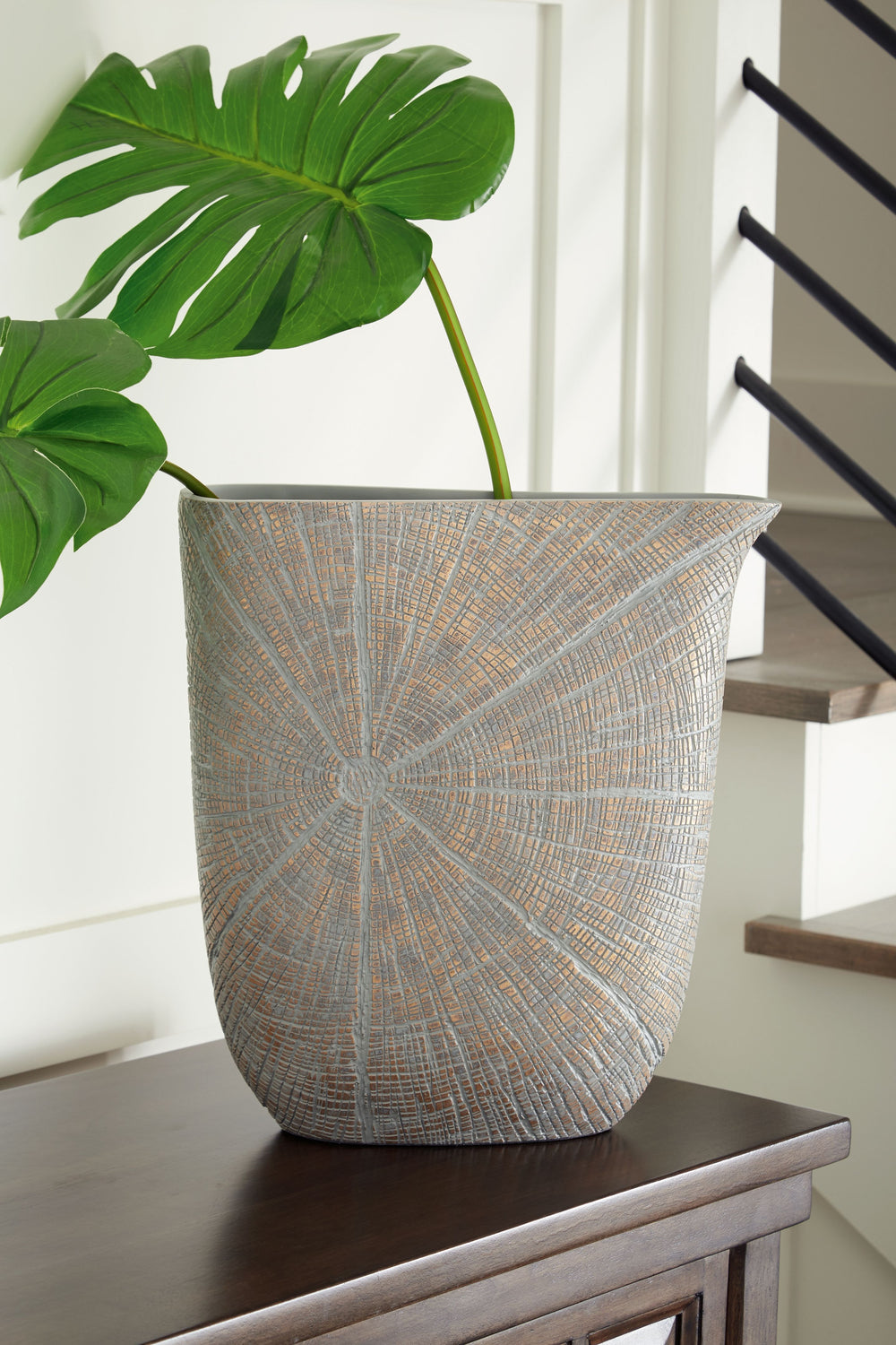 A unique mix of primitive and modern, this vase has an exquisite artisanal appeal. Its wide mouth holds your most bountiful bouquets. The vaseâ€™s intriguing silhouette and starburst pattern capture the eye, complementing a room that craves sophistication