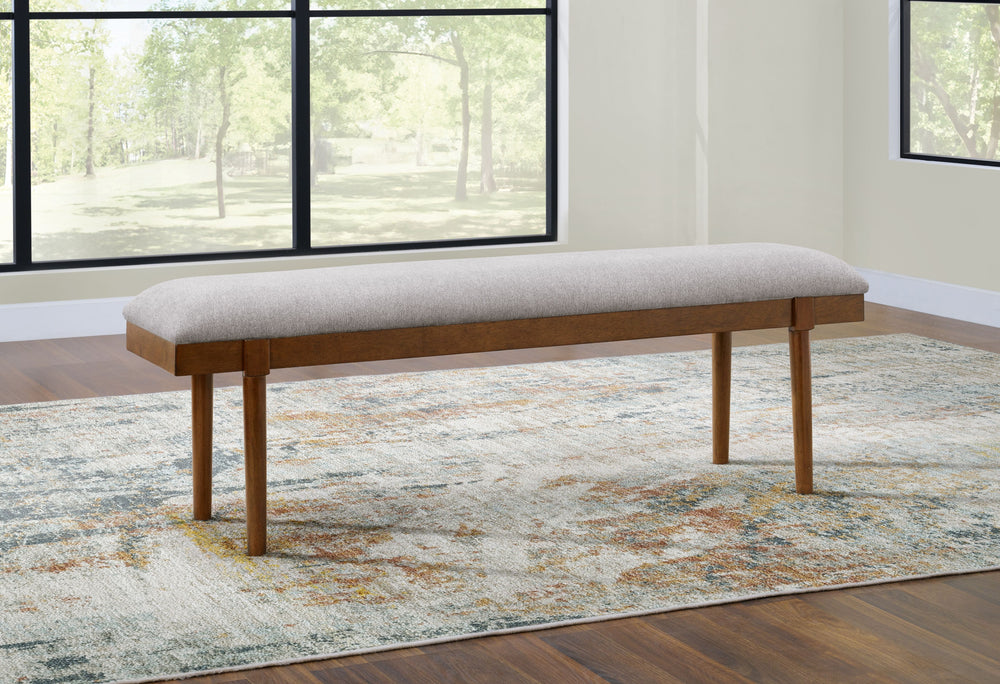 A refreshed take on retro aesthetics. This upholstered bench adds an air of simplicity to your dining space, capturing the architectural language of mid-century stylings. Its seat invites the eye with a soft-edged silhouette and neutral gray cushion. A ca