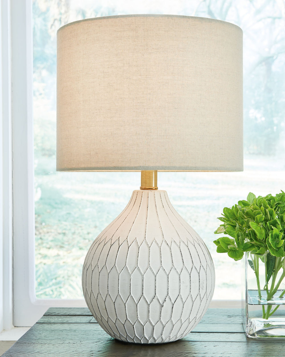 Fresh and light, the dimensional design of this delightful ceramic table lamp borrows from a retro theme to update a transitional space. Made of ceramic with an antiqued white finish, this accent lamp infuses personality into any setting. Add it to a cons