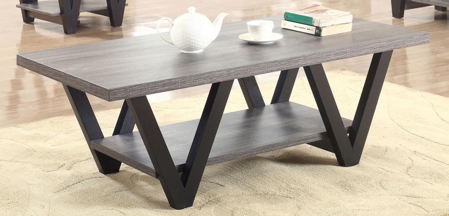 This contemporary coffee table enhances your living room with its bold, angular design and practical features. A rectangular grey wood-look top and lower shelf, crafted from engineered wood with a durable laminate veneer, provide stylish and functional su