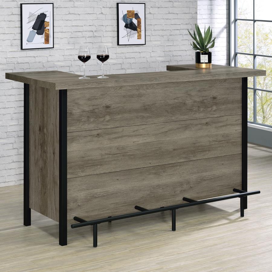 Add functionality and style to an entertainment space with this rustic bar unit, appointed in a gray driftwood-inspired finish with distinctive metal details throughout. Perfect for holding and organizing barware, bottles and all your mixologist essential