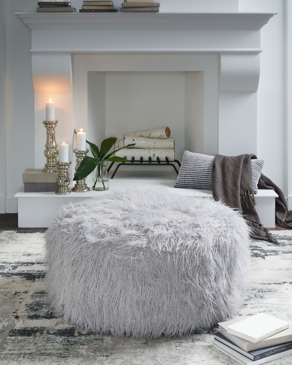 Don-'t shy away from decadence. Add a bit of bold design to your room with this oversized accent ottoman. The faux fur upholstery has a luxe look, and its casual light gray hue allows this plush piece to make a stylish statement in a variety of spaces.<br