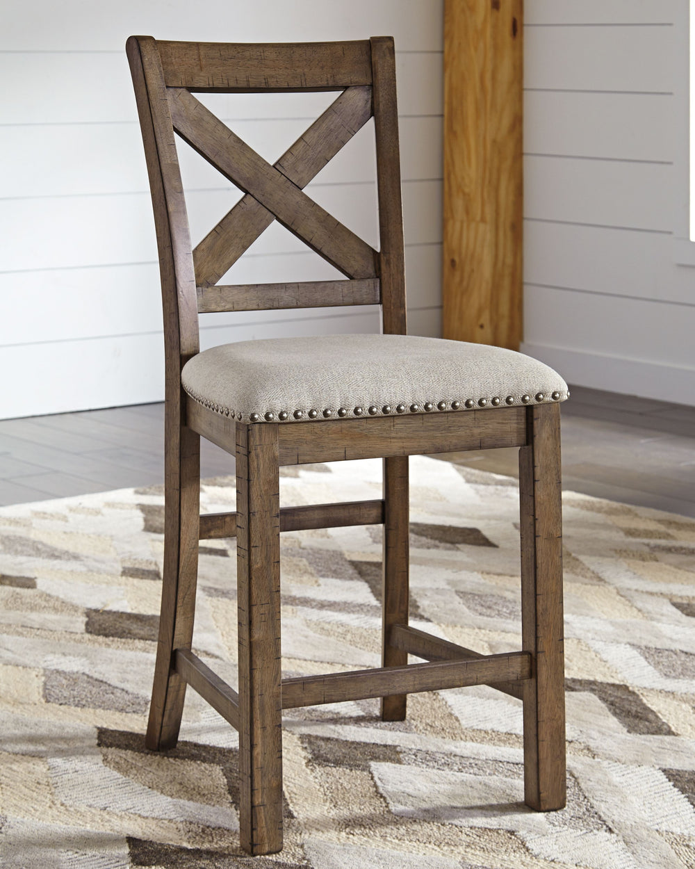 This upholstered bar stool might be simple at first sight, but a closer look reveals beauty in the details. With a distressed nutmeg finish, antiqued nailhead trim and textured polyester upholstery, it-'s beaming with charm. Cushioned seat ensures long, l