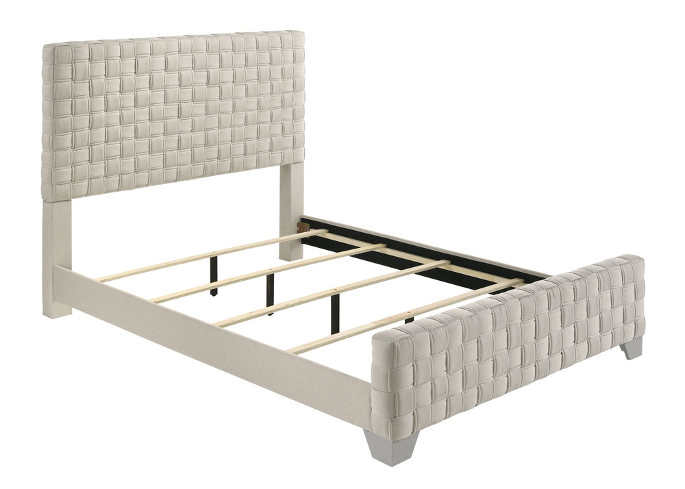 This bed is a statement piece that brings a touch of luxury and contemporary design to any bedroom setting. It features an oversized, padded headboard with a detailed basketweave pattern that adds texture and sophistication. The upholstery is crafted with