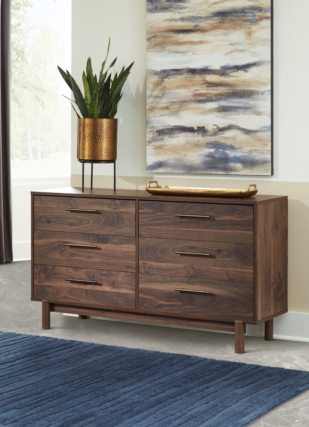 At the intersection of industrial cool and chic sophistication, youâ€™ll find this dresser. With a rich brown finish over replicated walnut wood grain, paired with burnished goldtone handles, it offers an authentic touch that plays well any way you style 