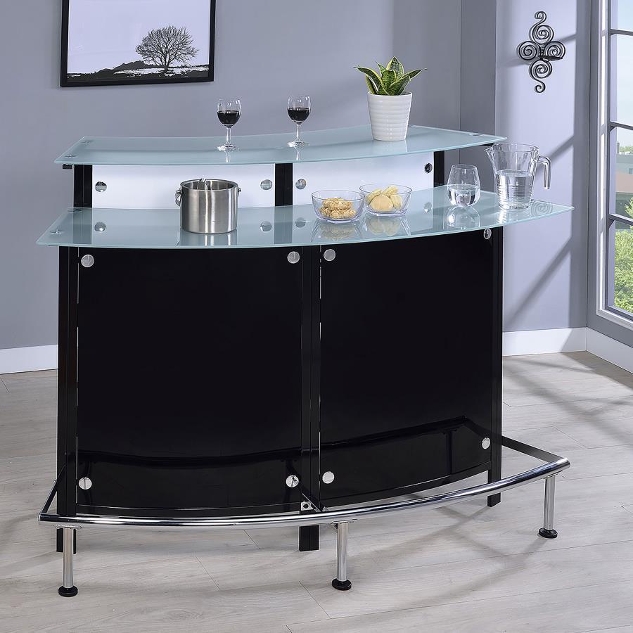 Entertain in sleek sophistication with this modern home bar, featuring a curved silhouette, chrome accents, and glossy black and white acrylic panels. Dual-tiered frosted glass tops offer ample space for mixing and serving, while the metal footrest invite