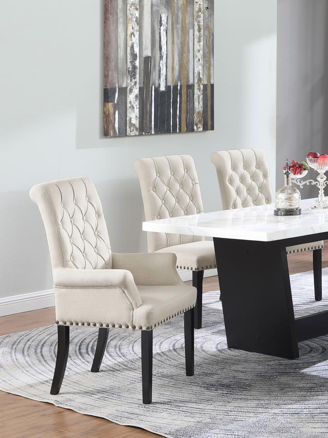 Designed for both luxury and support, this arm chair brings an elegant presence to any dining space. Its button-tufted high back and rolled top lend a timeless aesthetic, while the addition of padded armrests enhances comfort. Hand-applied nailhead trim o