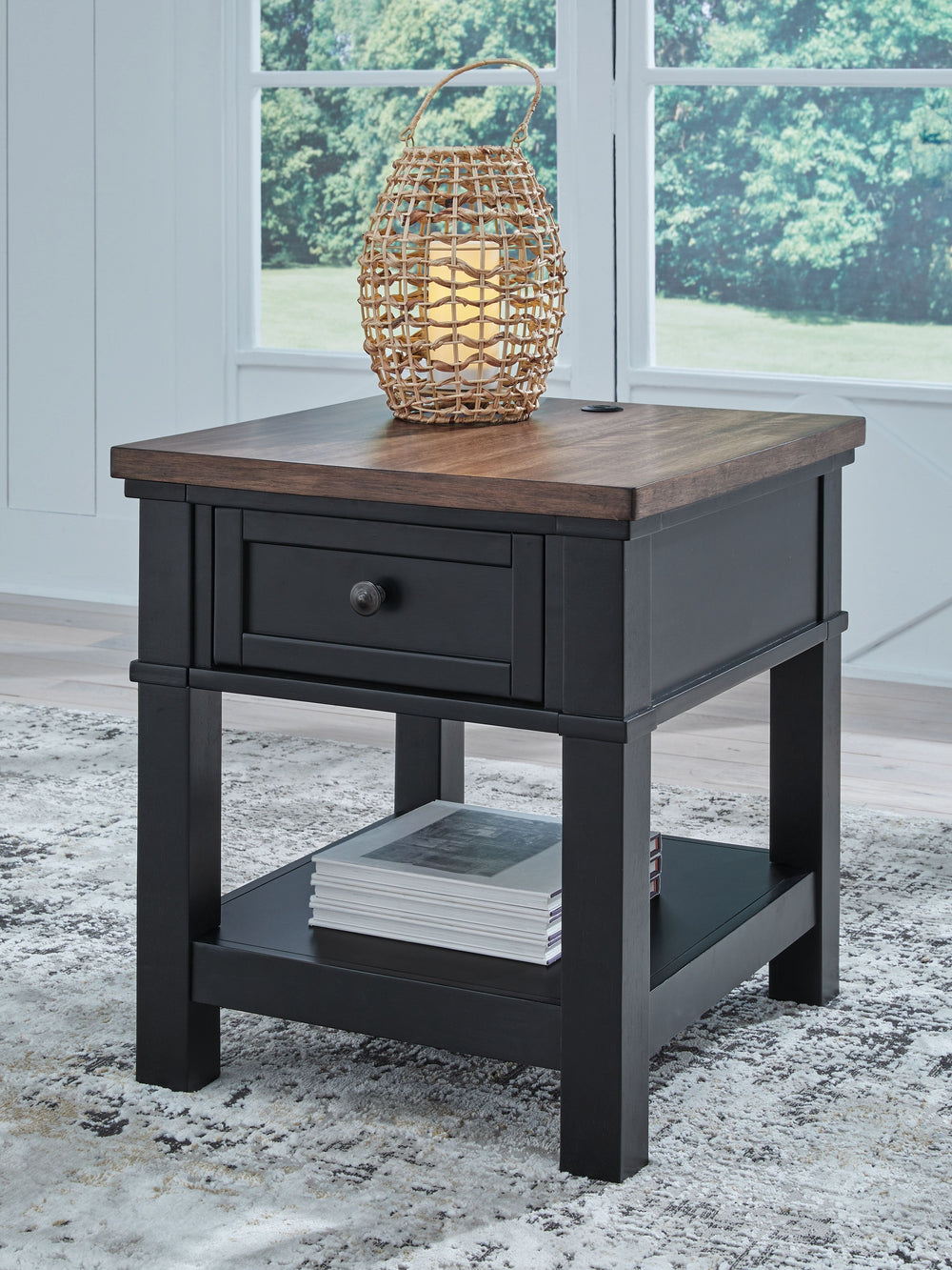 Raise the bar on modern farmhouse style with this end table. Its sturdy silhouette and casual good looks are accentuated with a two-tone finish, which pairs a warm satin black base with a contrasting butcher block veneer top. A spacious storage drawer and