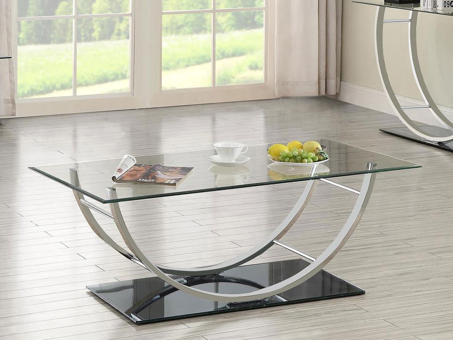 This contemporary rectangular coffee table features a clear tempered glass top and a sleek tempered mirrored base for a polished and modern appeal. The elegantly curved frame, crafted from electroplated heavy gauge metal in a chrome finish, enhances its s