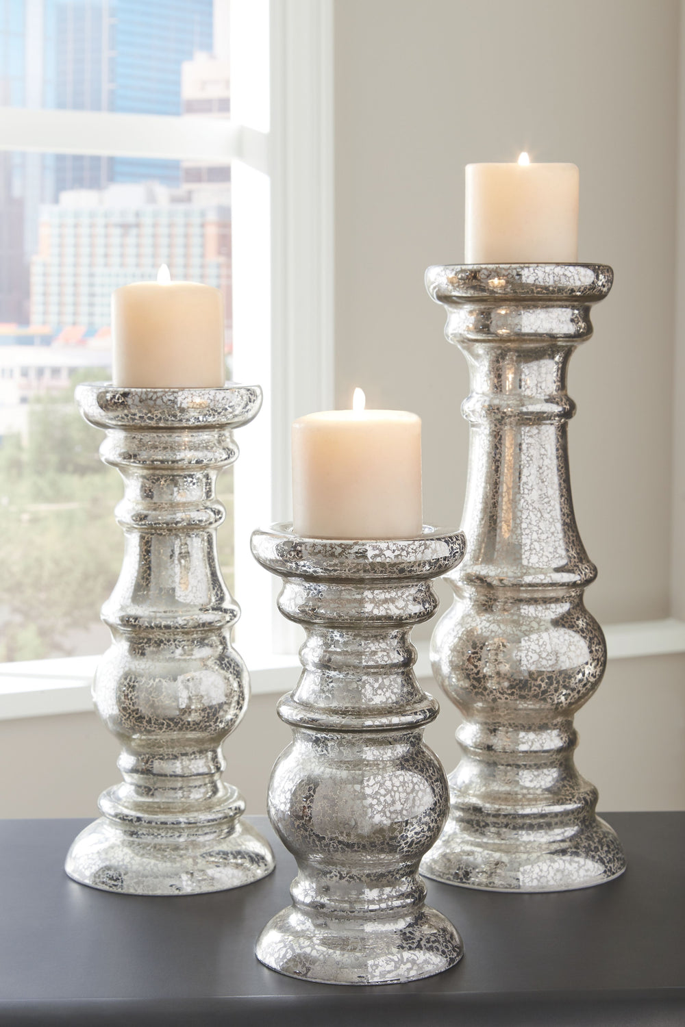 The turned silhouettes of this 3-piece candle holder set create gorgeous negative anywhere in your home. Silvertone finished mercury glass elevates the look with a hint of shine. With candles lit, an enticing aroma fills the air to complement your contemp