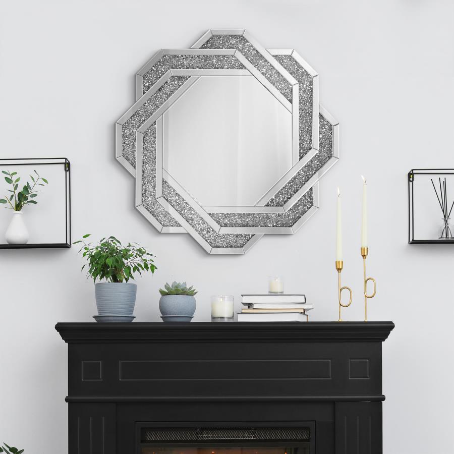 This decorative wall mirror features a striking octagonal silhouette with a mirrored frame inset with faceted acrylic crystal inlay. Designed to make a statement, the overlapping geometric pattern brings dimension and a touch of glam to any room. Without 