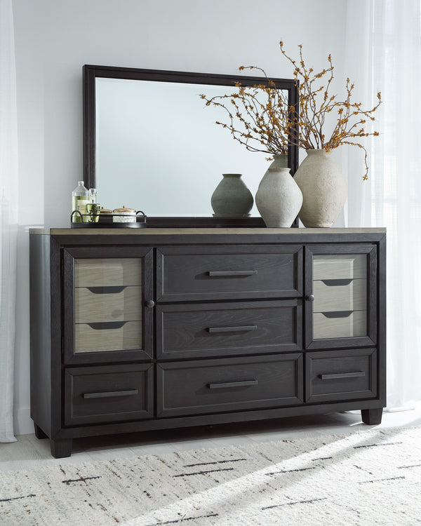 This dresser and mirror set is casual contemporary style simply done right. Its two-tone color scheme features a rich brushed black main color accented with a beautiful dusty grayish brown wood tone. With 11 soft-close drawers (three located neatly behind