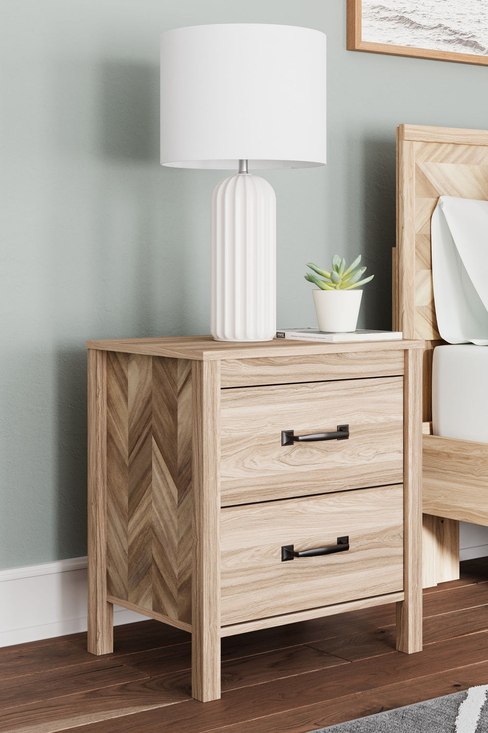 Transform your bedroom into an instant sanctuary. Pairing the look of oak grain with a unique chevron pattern, this nightstand introduces a touch of mid-century modern style that-'s sure to elevate your space. Catering to your busy lifestyle, this nightst