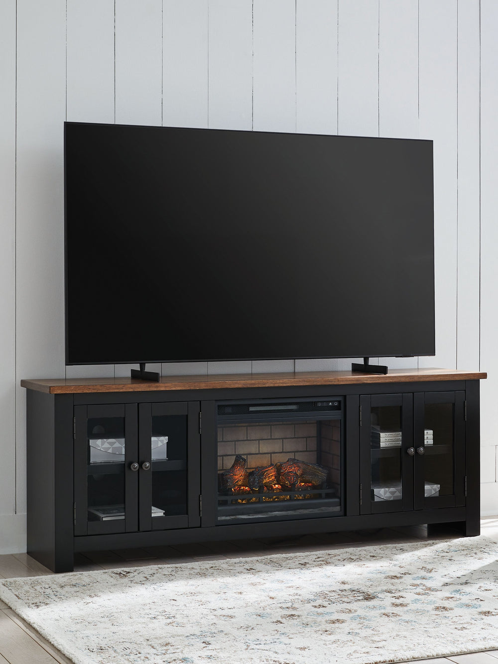 Raise the bar on modern farmhouse style with this TV stand with electric fireplace. Its sturdy silhouette and casual good looks are accentuated with a two-tone finish, which pairs a warm satin black base with a contrasting butcher block veneer top. Glass 