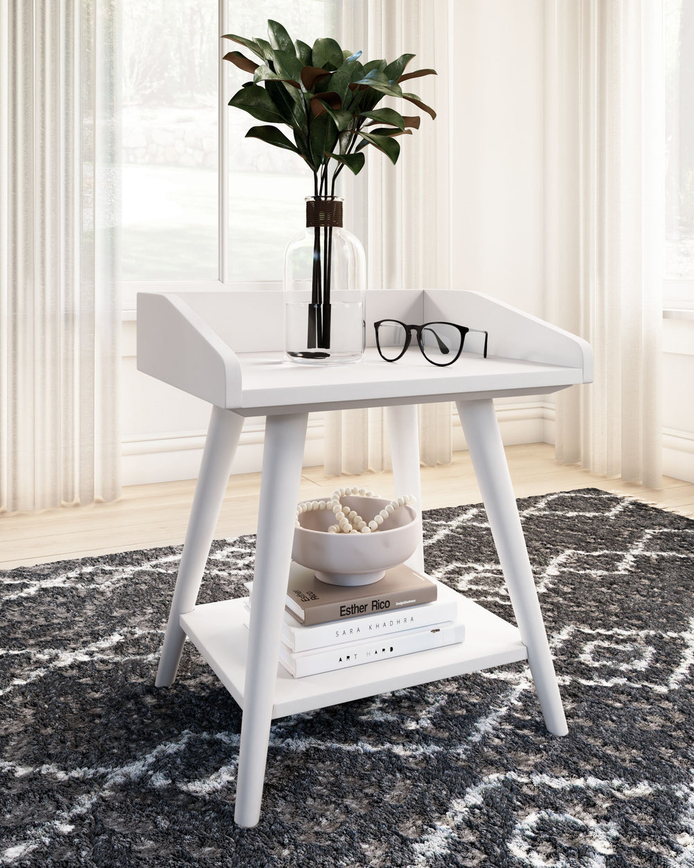 Display your decor with simple style on this accent table. Constructed of wood and engineered wood in a crisp, white finish, this table blends easily with your existing living room aesthetic or stands in as a kid-'s bedside table. A gallery rail top, unde