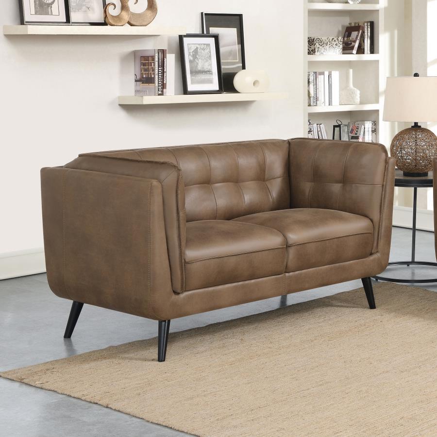 Complete your contemporary living room setup with this mid-century modern shelter style loveseat, designed as an updated take on the classic Chesterfield style silhouette including grid tufted seats and backs along with welt trim details. Upholstered in a