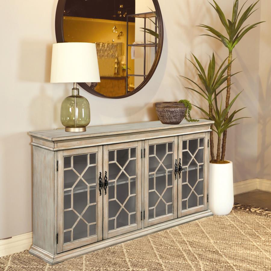 Add rustic charm and timeless elegance to your home with this farmhouse-inspired accent cabinet. A warm honey-toned finish and weathered detailing give it a country-style appeal, while decorative glass panel doors with intricate trim add a refined touch. 