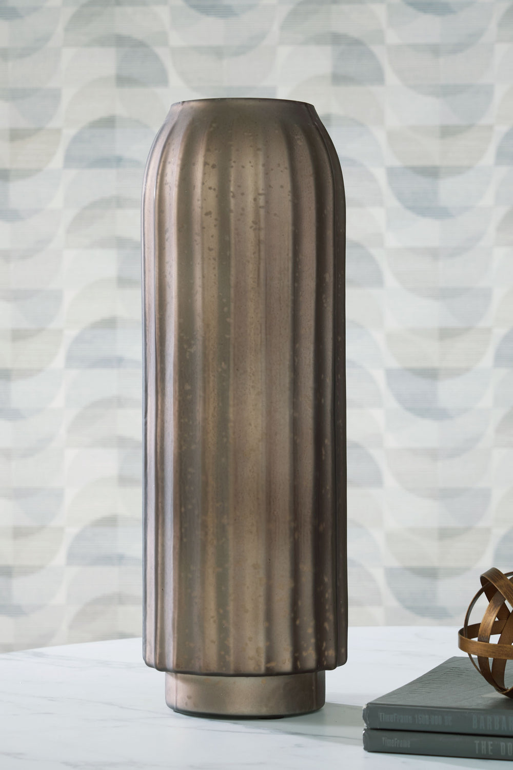If contemporary style speaks to your design sensibilities, this vase will captivate you with its on-point aesthetics. A stunning mercury glass finish and fluted design make it a visual delight. This exquisite piece effortlessly stands out on its own, or y