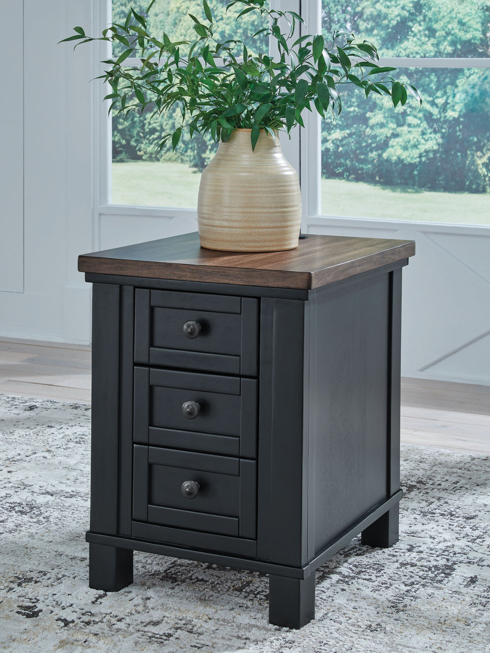 Raise the bar on modern farmhouse style with this chairside end table. Its sturdy silhouette and casual good looks are accentuated with a two-tone finish, which pairs a warm satin black base with a contrasting butcher block veneer top. Spacious storage dr