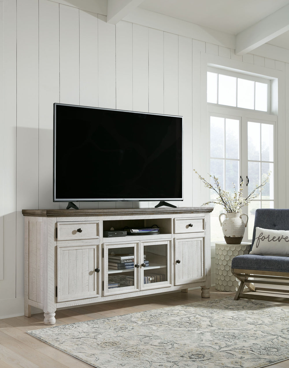 Have your fill of modern farmhouse style with this TV stand. Its distressed two-tone finish pairs a vintage white with a weathered gray for a look thatâ€™s utterly charming. Right and left cabinets open to reveal adjustable shelving for all your entertain