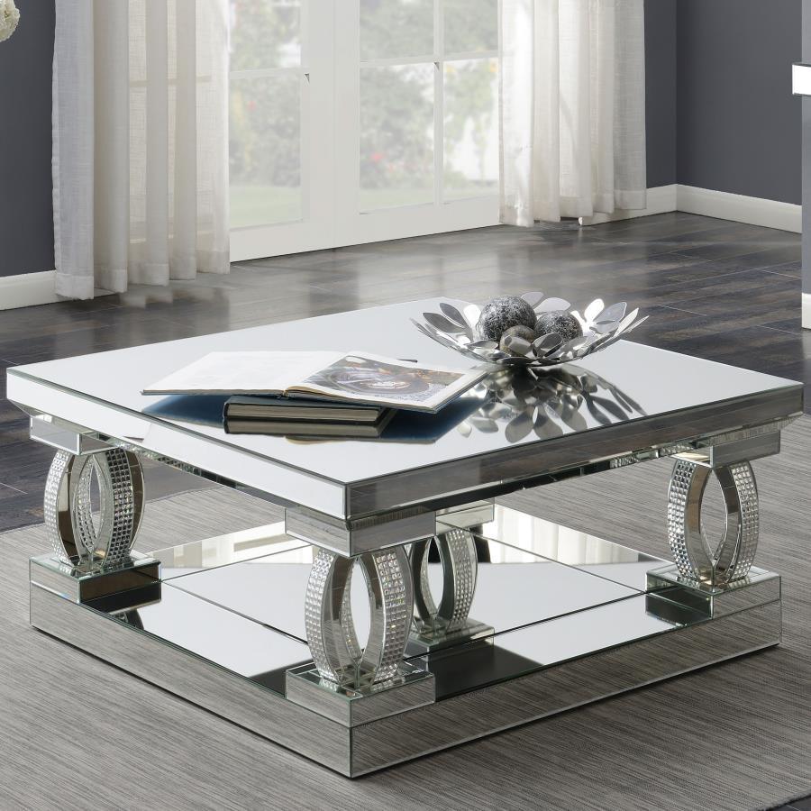 This 40-inch square coffee table brings bold, contemporary style to your living space. With its mirrored surfaces and sturdy construction, it features a large, symmetrical top and matching base for visual balance. Sculptural, oval-shaped supports adorned 