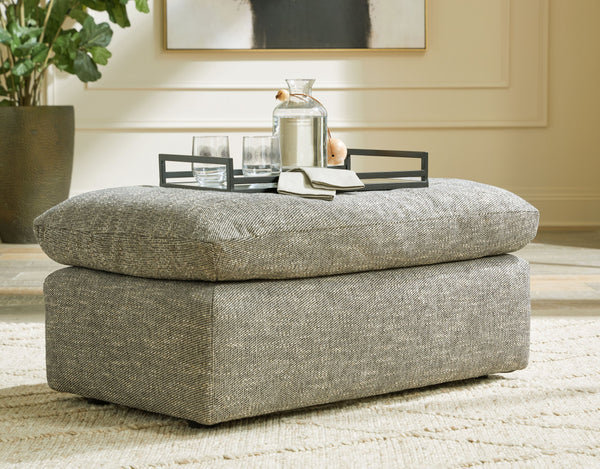  this ottoman provides a positively plush foot perch. Its feather-fiber blend cushion invites you to float away in cloud-like comfort. Striking granite-hued upholstery and a streamlined frame grant th