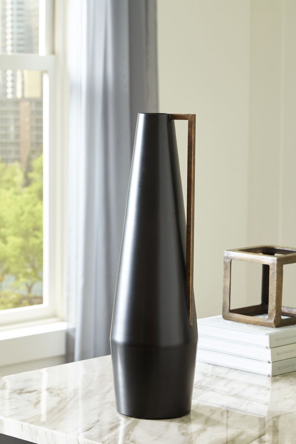 Keep your home contemporary cool from head to toe with this vase. Softly sloping in form, it-'s finished in a sleek black. An angular goldtone accent adds a dash of glam, creating a subtly dynamic overall design.<br/><br/><b>Product Features</b><ul><li>Ma