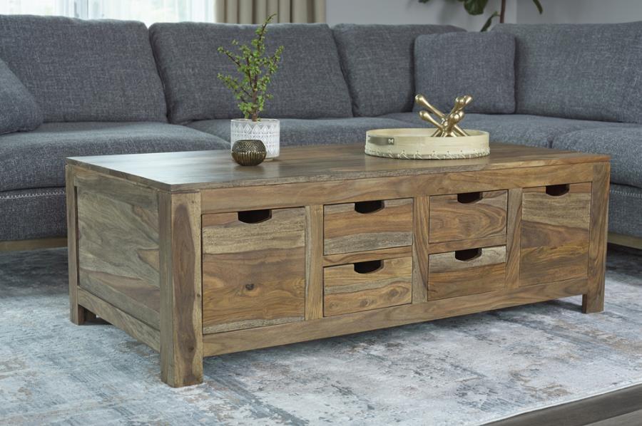 Dramatic wood grain accents lend classic character to this exquisite, wooden coffee table. This stunning piece is handcrafted with sheesham wood in a warm, light natural finish. A generous array of drawers provides ample storage space. The drawers are des