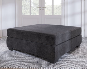  the firmly cushioned square ottoman is covered in a decadently soft