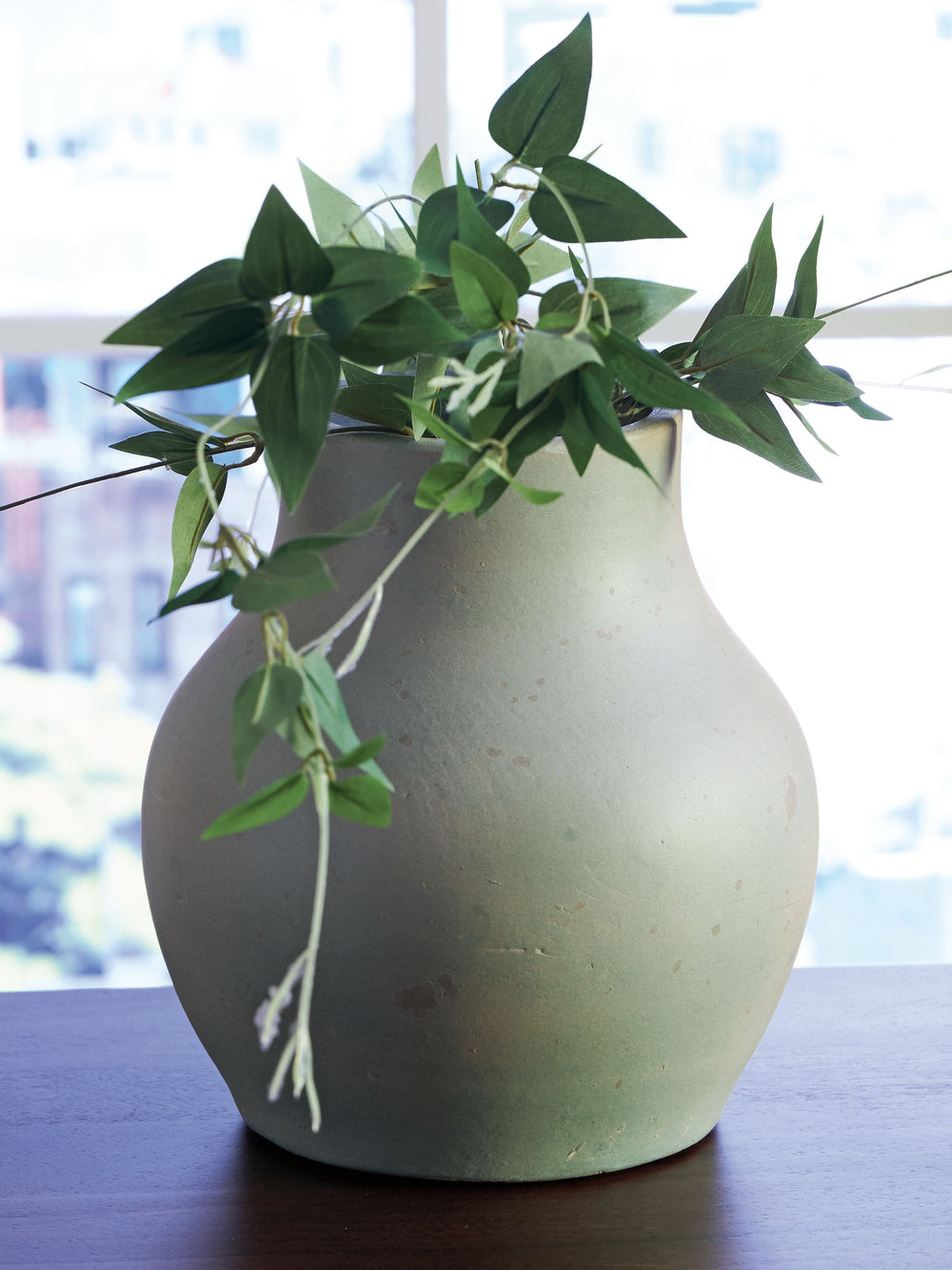 Bring a touch of rustic charm and casual elegance to your home with this terra cotta vase. The antiqued green finish gives it a beautifully weathered look, adding character to your creatively curated space. Let the piece shine on its own, or change things