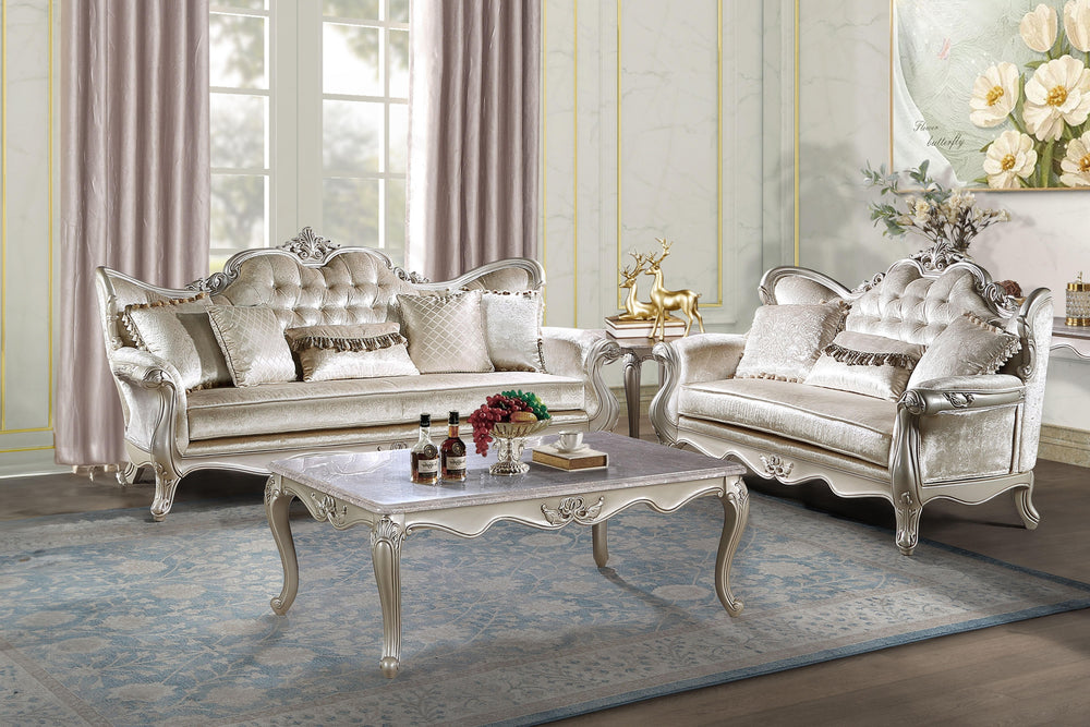 The Monique 2 Piece Royal Classic Living Room Set, in a resplendent champagne finish, epitomizes heirloom-quality craftsmanship and timeless elegance. Meticulously constructed from premium pine solids and adorned with durable polyurethane carvings, this s