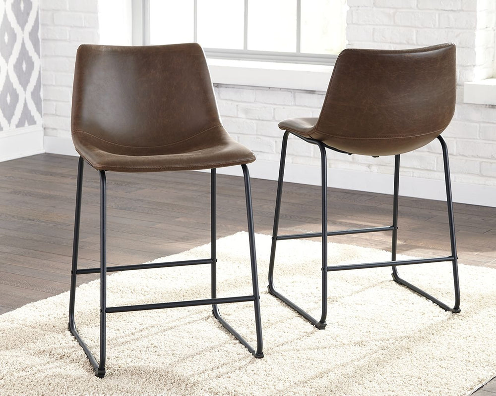 With its distinctive contoured bucket seat and tubular metal base, this upholstered bar stool serves up a fresh twist on mid-century inspired style. Practical faux leather has a charmingly vintage tone. What a timeless look for eat-in kitchens and casuall