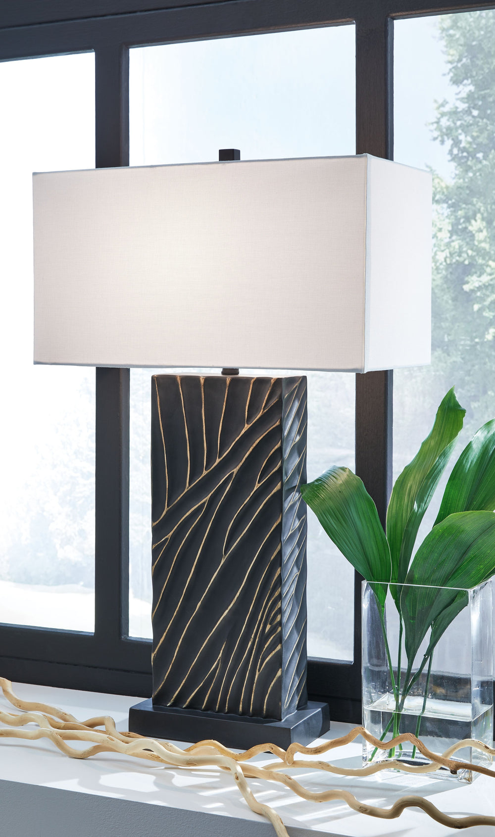 Kick your style up a notch with this table lamp. The impressive black base boasts textured detail enhanced with striking gold accents for sophisticated flair. Its eye-catching form exudes an urbane yet casual vibe, making it an easy addition to existing d