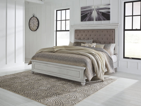 Give your retreat vintage charm with this king upholstered panel bed. In a beautifully distressed whitewash finish, you-'ll love the headboard-'s grand style featuring an inset button tufted upholstery cushion. Generously scaled moulding from top to botto